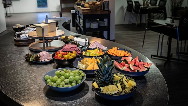 Una mesa de buffet con diversos alimentos, como frutas, verduras y carnes.