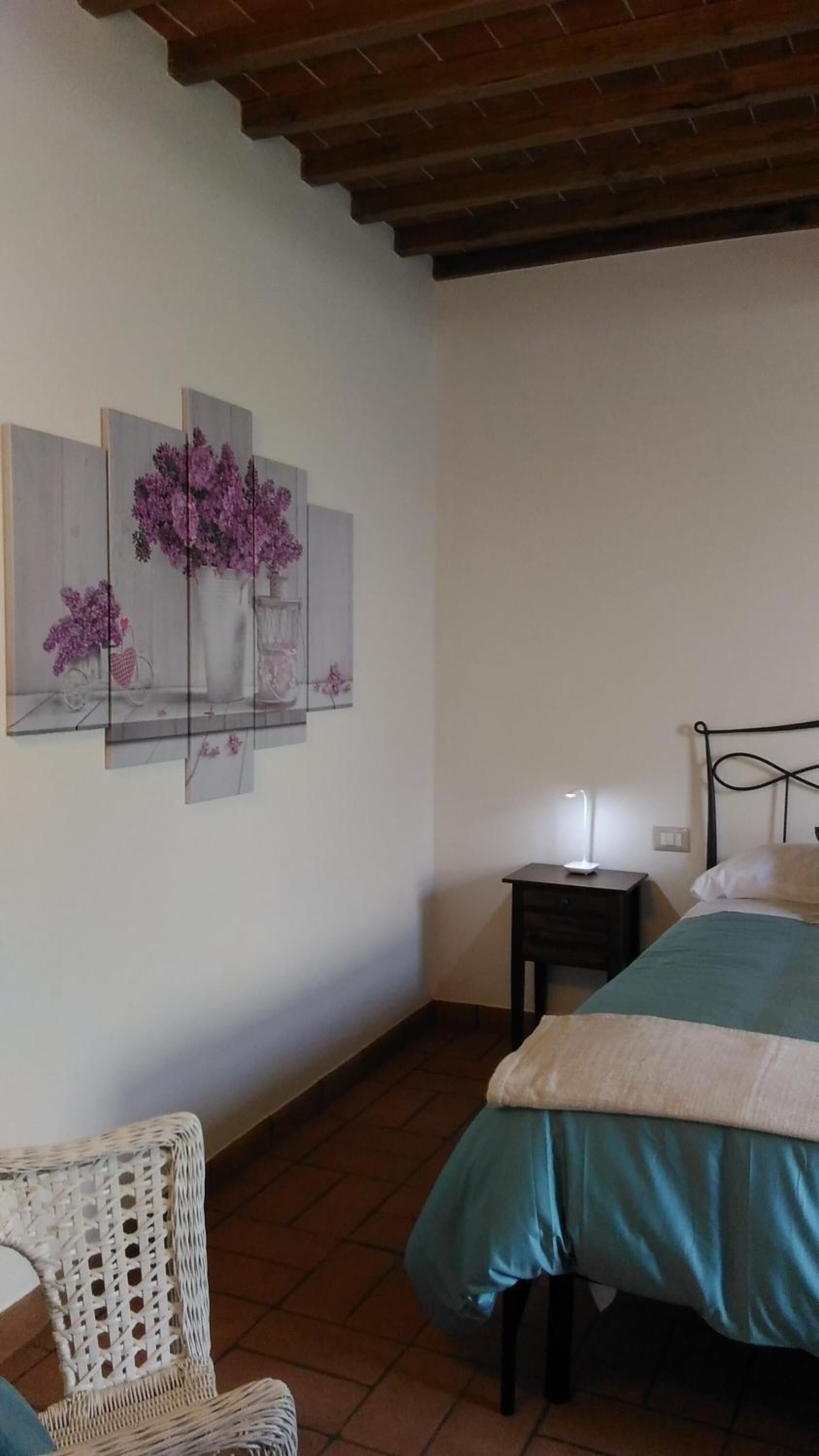 Une chambre à coucher comprenant un lit, une table de chevet, une chaise et des œuvres d’art murales.