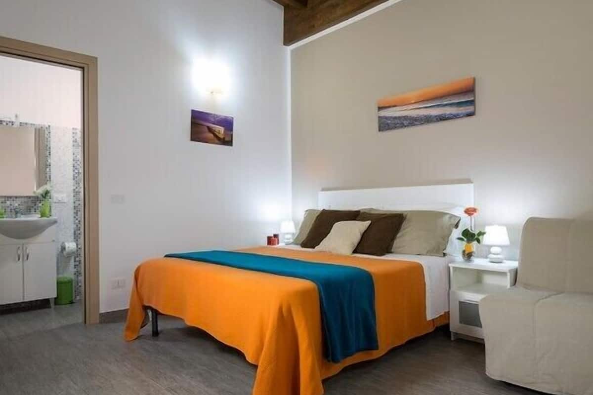 Ein Schlafzimmer mit Bett, Nachttisch und Stuhl.