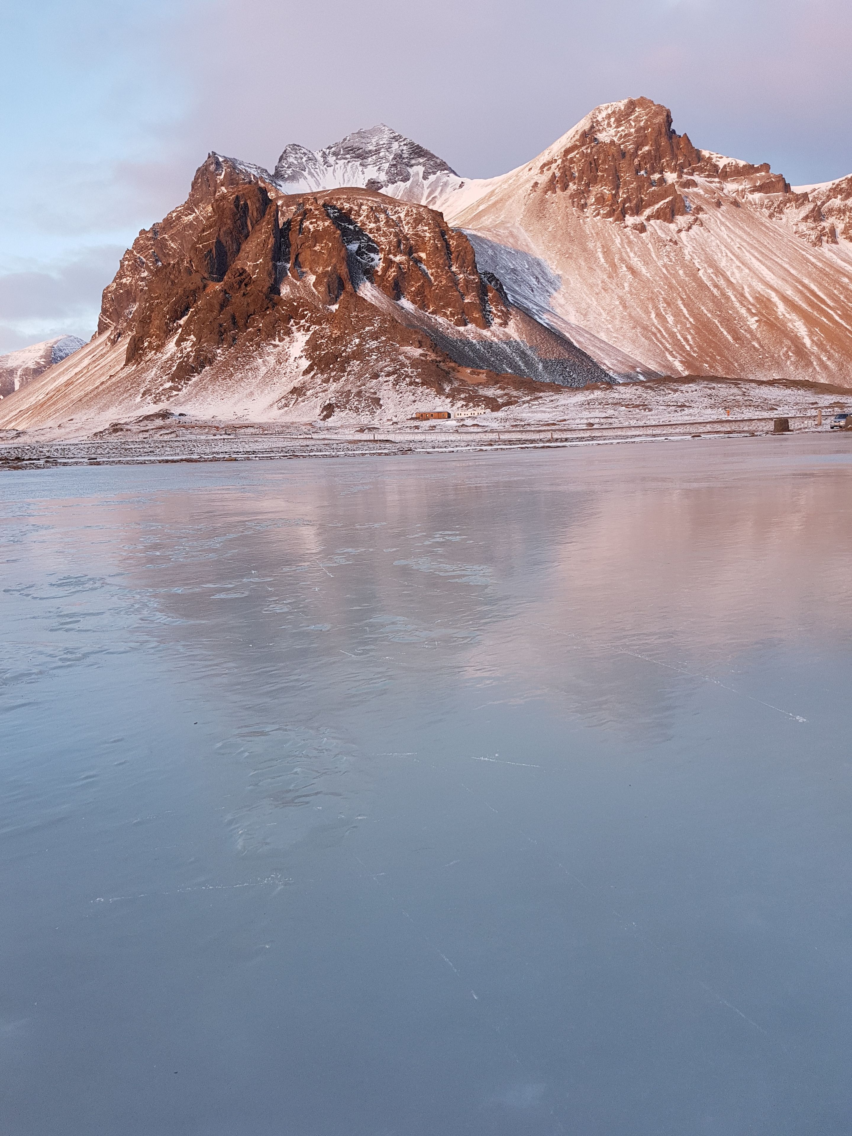 A frozen lake with mountains in the background.