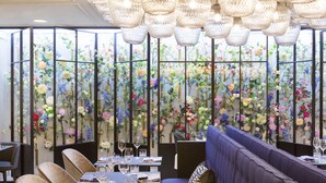 A restaurant with a blue sofa, dining tables, and a decorative floral wall. - THE FRITZ Düsseldorf (Düsseldorf)