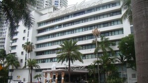 A multi-story hotel with a prominent 'Castillo' sign, palm trees, and a covered entrance area.