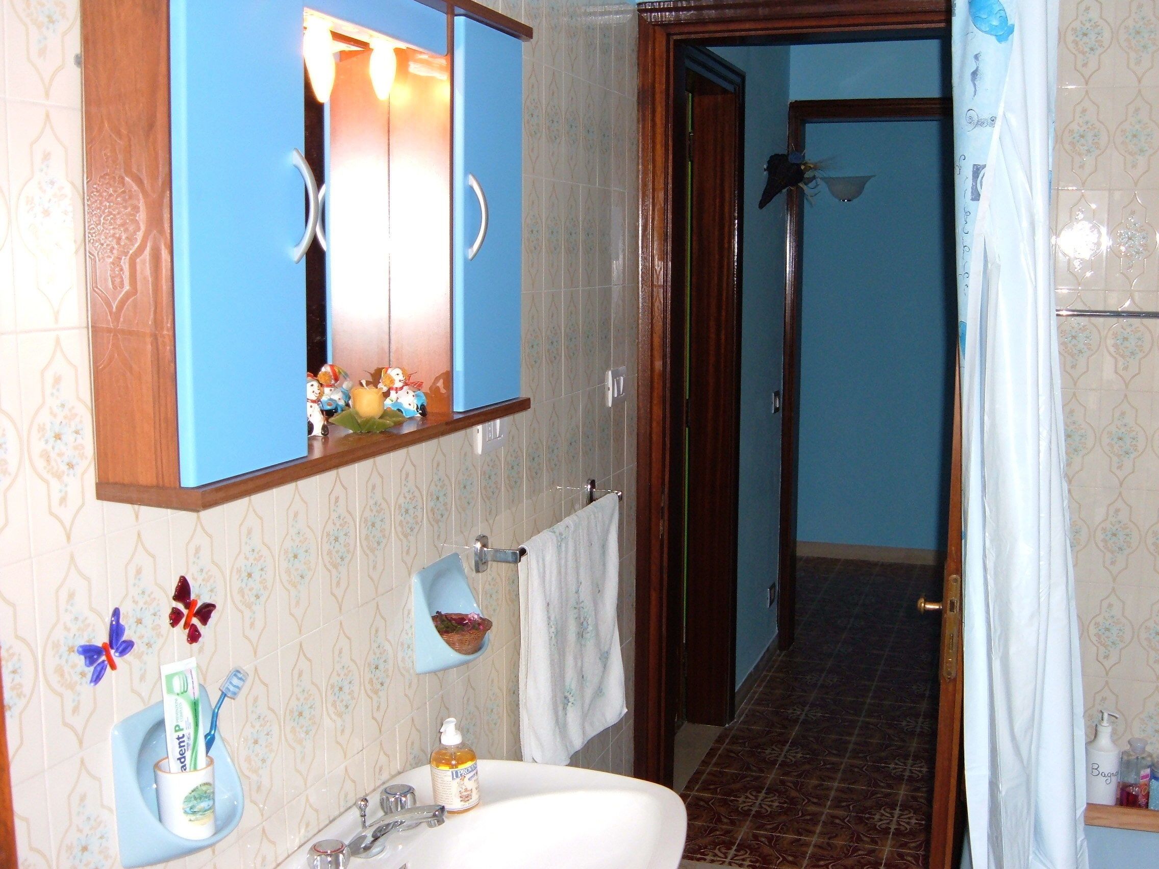 Une salle de bain équipée d’un lavabo, d’un miroir et d’une zone douche.
