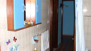 Une salle de bain équipée d’un lavabo, d’un miroir et d’une zone douche.