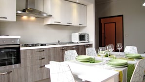 A modern kitchen with a dining area. It includes a stove, microwave, and cabinets. - Delfino2 Casesicule, Nice Apartment with Balcony, Sand Beach at 70 mt, Wi-Fi (Pozzallo)