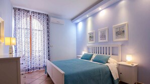 A bedroom with a bed, nightstands, a dresser, and a window with curtains. - Delfino2 Casesicule, Nice Apartment with Balcony, Sand Beach at 70 mt, Wi-Fi (Pozzallo)