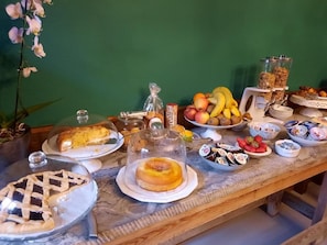 A breakfast buffet with various food items and a potted orchid. - Art Hotel Pietrasanta (Pietrasanta)
