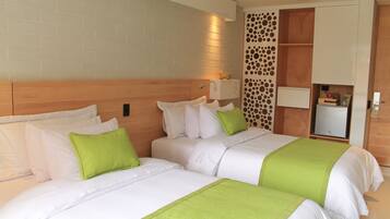 A hotel room with two beds, a brick wall, a wooden headboard, a wall-mounted light, and a storage unit with a decorative panel.