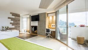 Une chambre d’hôtel moderne dotée d’un grand lit, d’un bureau, d’une télévision et d’un balcon avec vue.