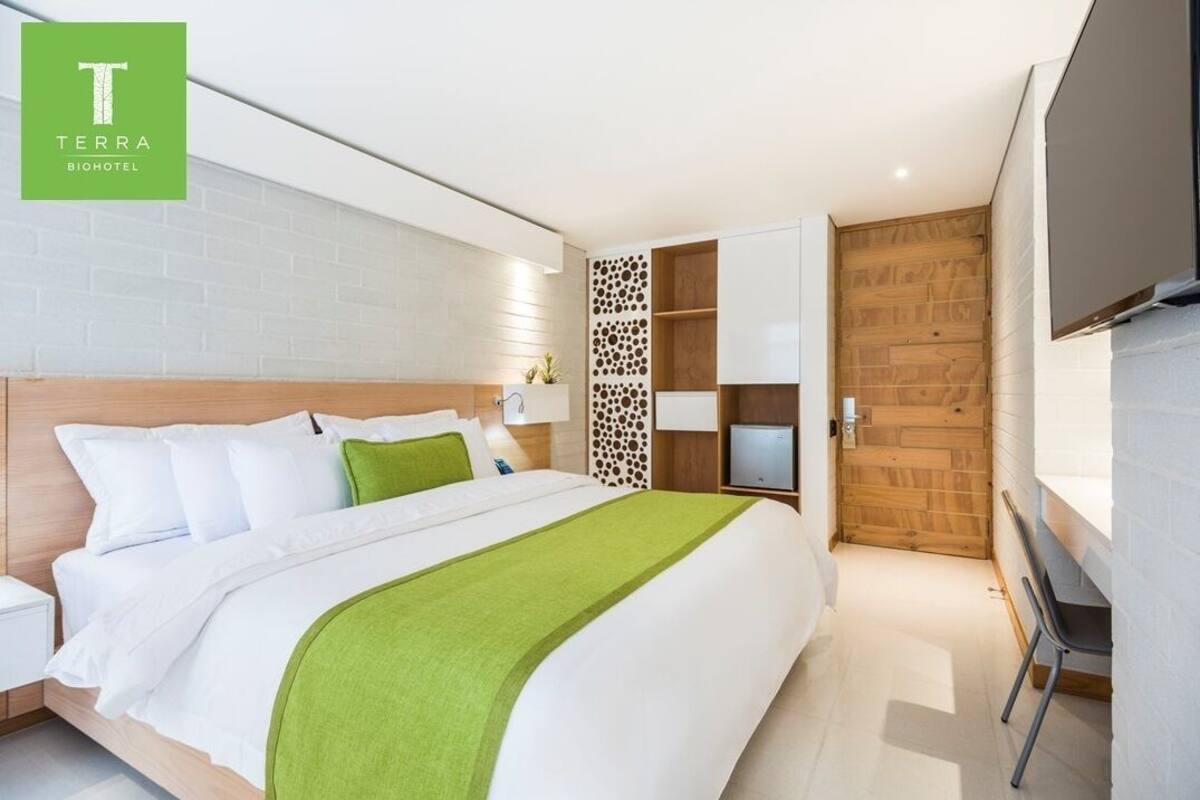 Een moderne hotelkamer met een groot bed, een televisie en een houten wandpaneel.