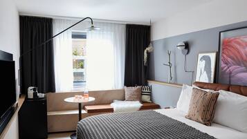 Une chambre d’hôtel moderne avec un lit, un canapé et une petite table.