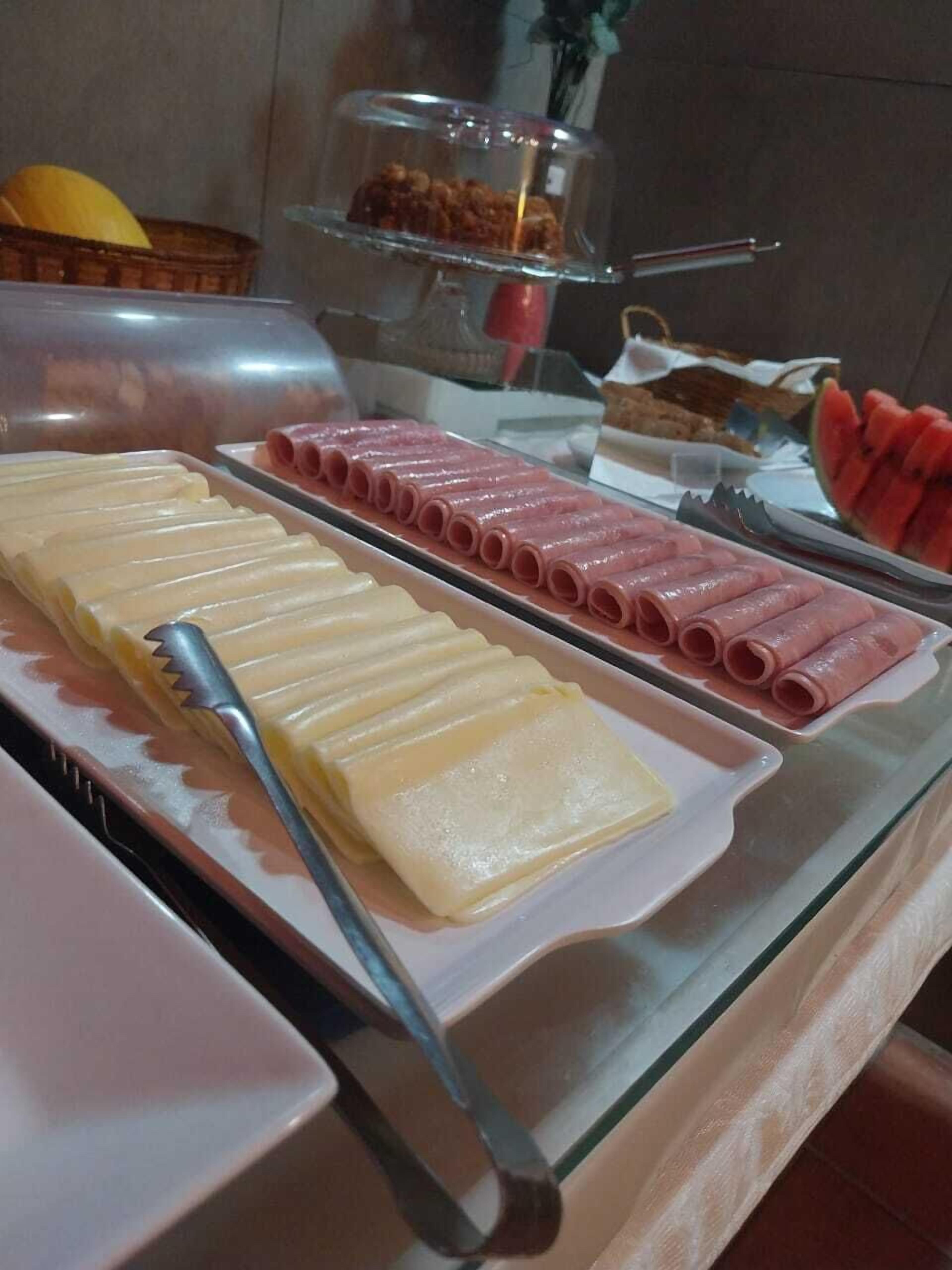 A buffet with various food items including sliced meats and cheeses.