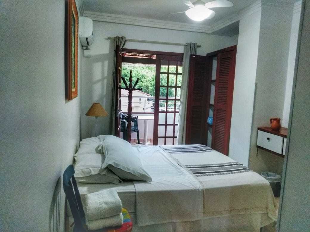 A bedroom with a bed, a nightstand, a lamp, and a window with curtains.