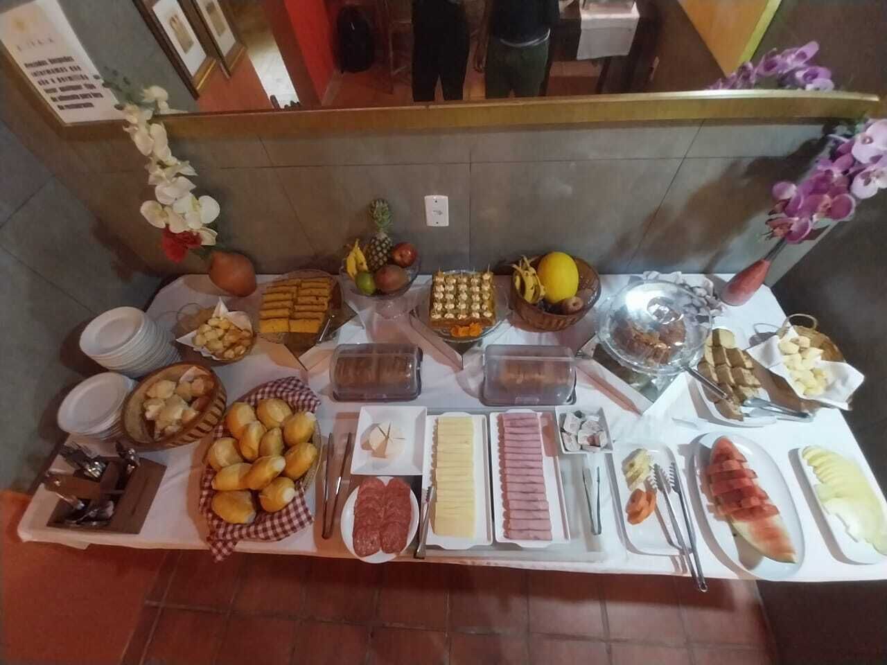 A buffet table with various food items including bread, fruits, and meats.