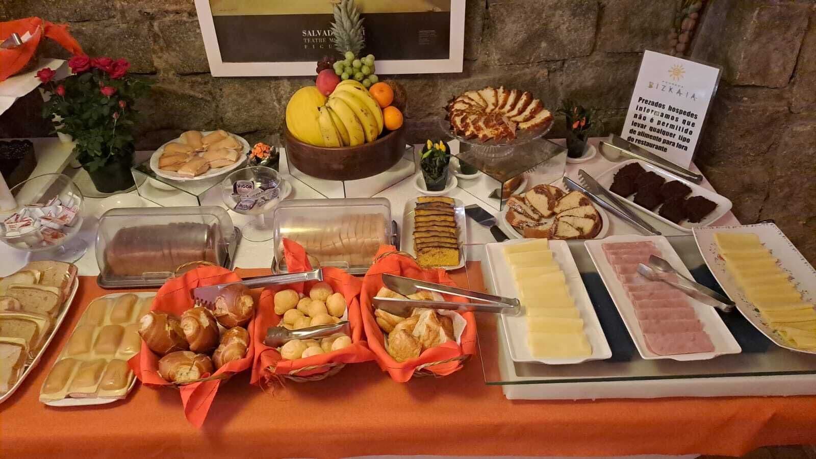 Ein Buffet mit verschiedenen Speisen, darunter Obst, Gebäck und Käse.