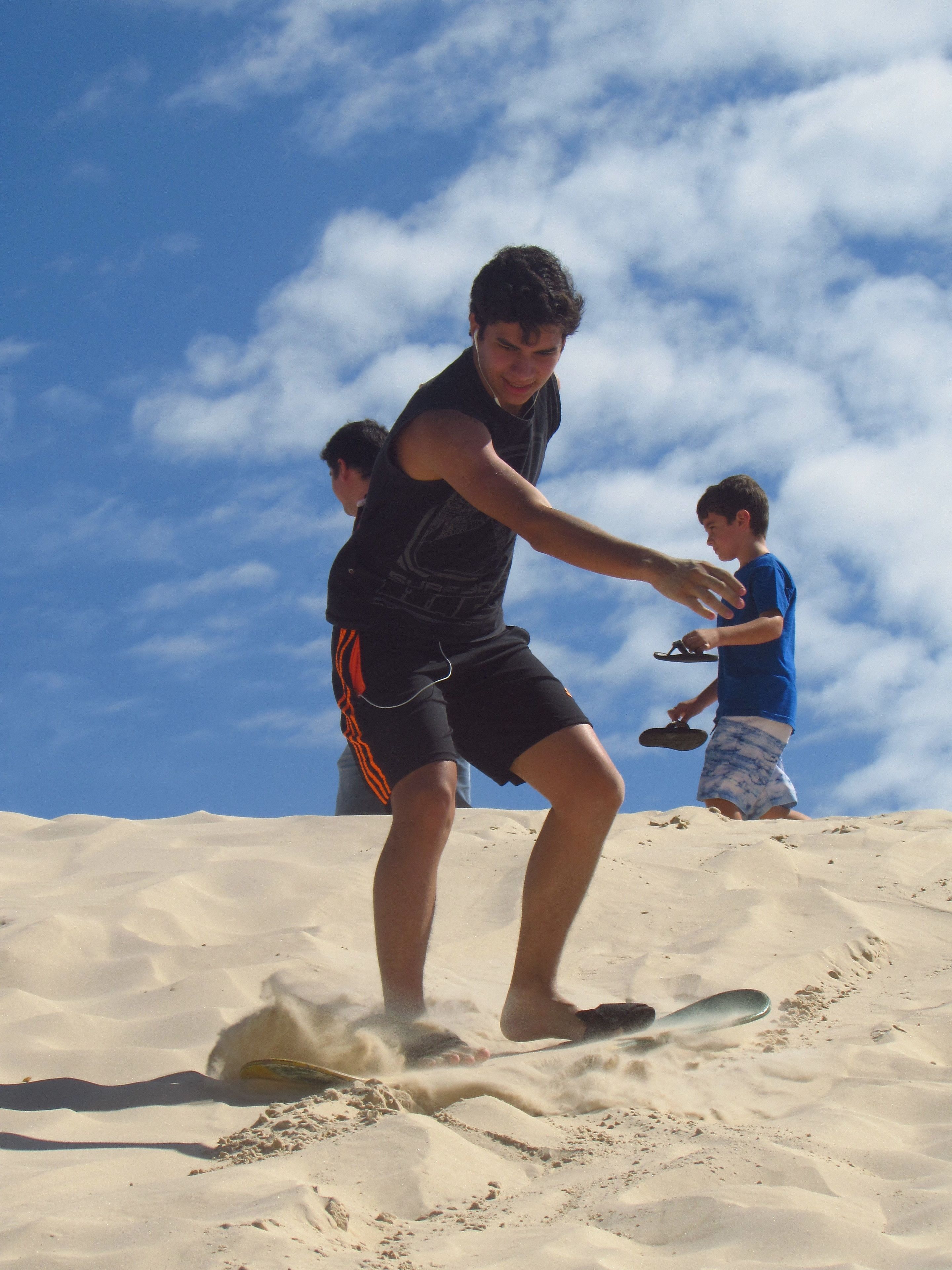 Alguém escorregando em uma encosta de areia.
