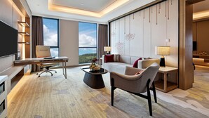 A modern hotel room with a desk, sofa, and a large window offering a scenic view. - Holiday Inn Chengdu Qinhuang by IHG (Chengdu)