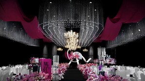 Un lieu de réception pour mariage doté d’une allée centrale, de décorations florales et d’un lustre.