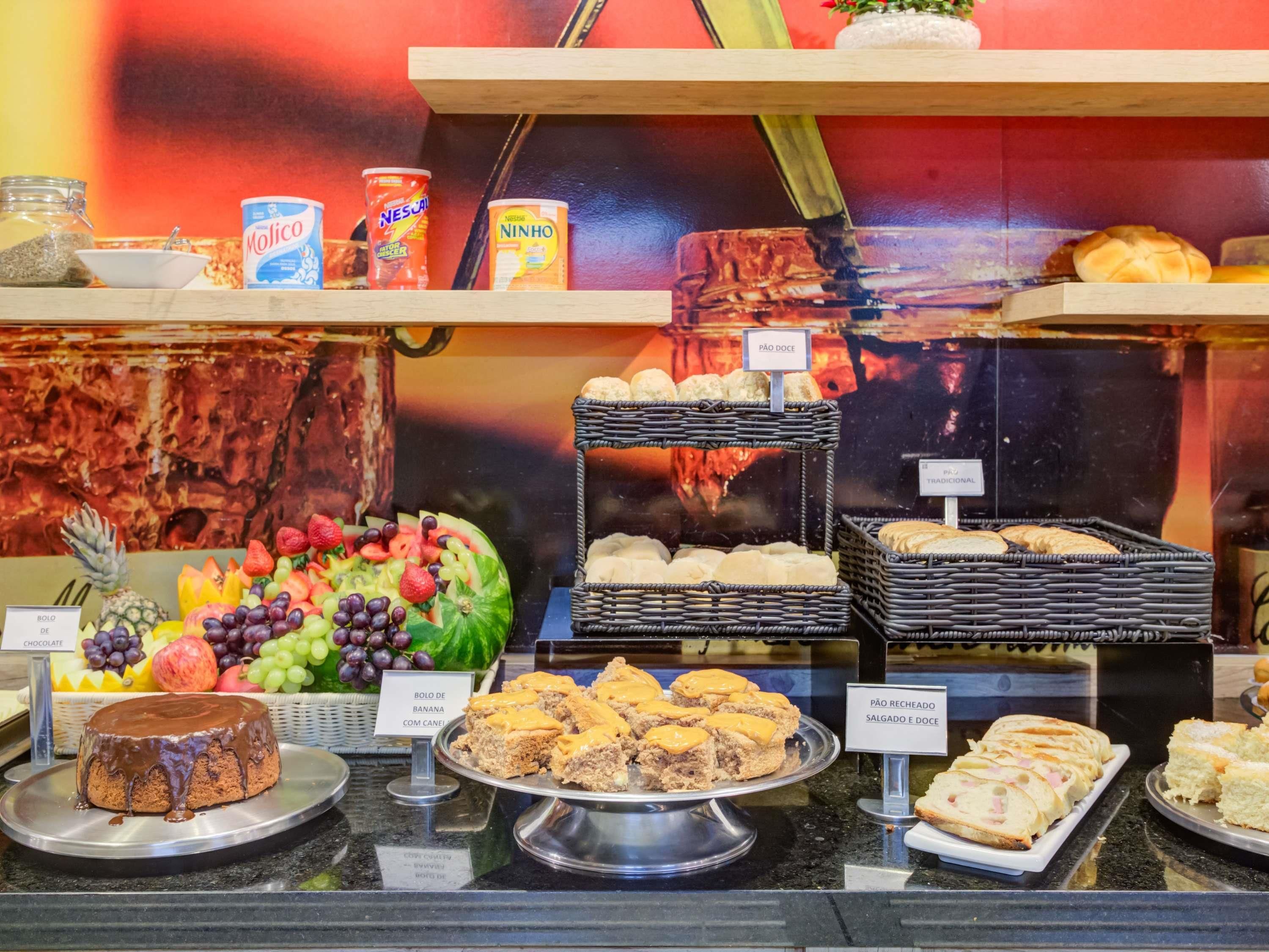 Ein reichhaltiges Buffet mit verschiedenen Speisen, darunter ein Schokoladenkuchen, Obst und unterschiedliche Brotsorten.