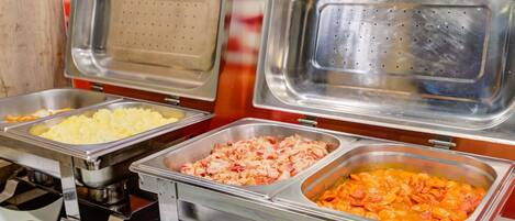 Un bufé con recipientes etiquetados para diferentes alimentos.