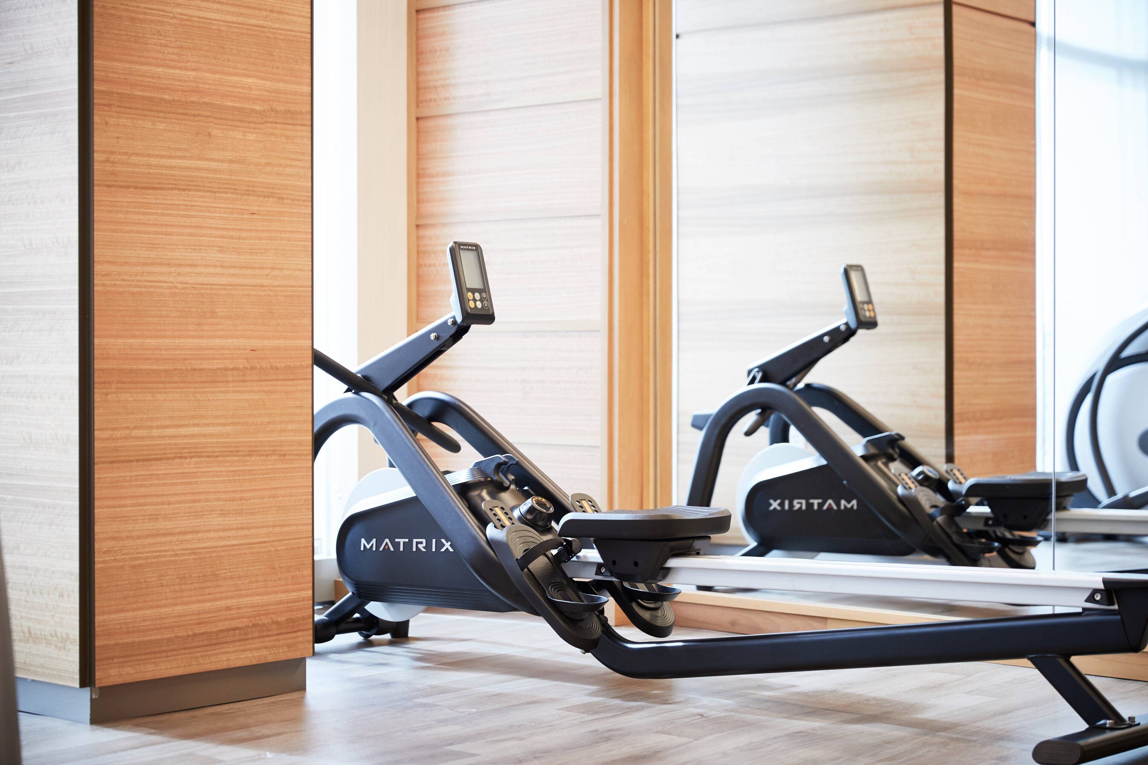 Two stationary bikes labeled MATRIX in a modern gym with wooden flooring and mirrored walls.
