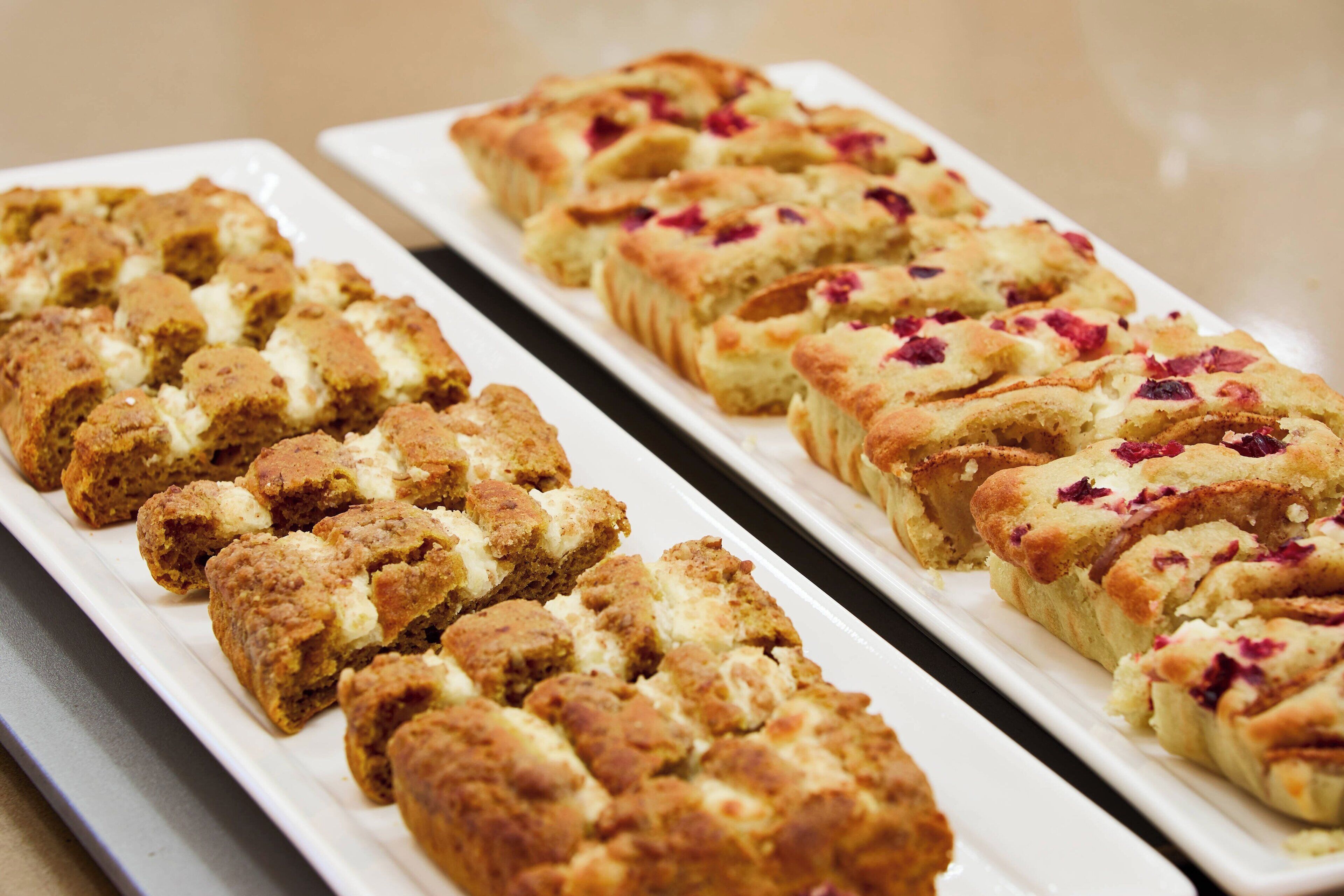 A tray of baked goods, possibly pastries or desserts, arranged on a white plate.