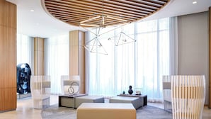 A modern lobby with a central seating area, a unique ceiling design, and large windows.