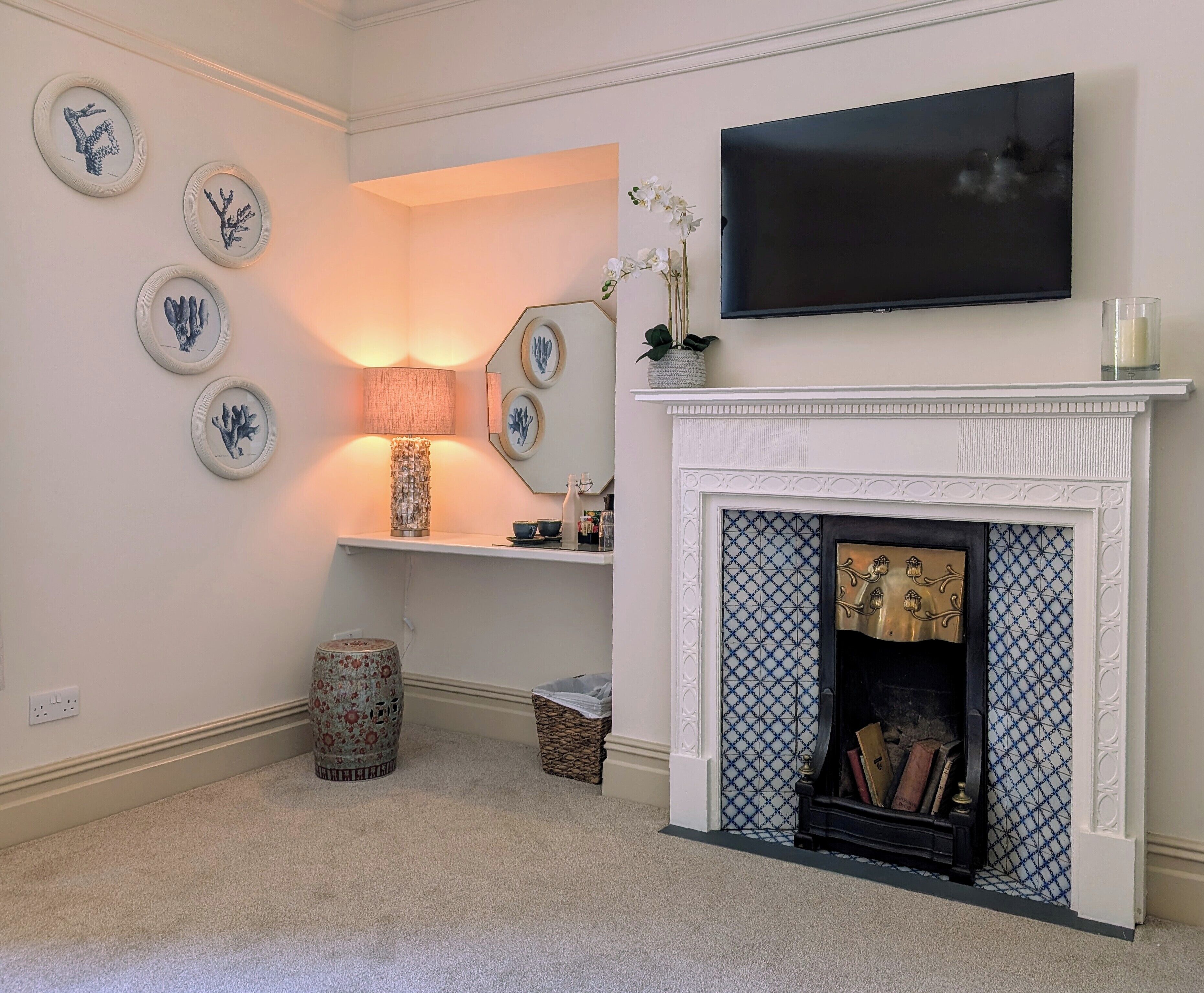 A living room with a fireplace, a mounted TV, and decorative wall art.