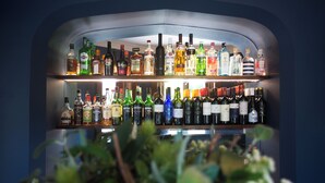 Un bar con varias estanterías llenas de botellas de licores.