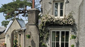 Un área de estar al aire libre con un edificio de piedra al fondo.
