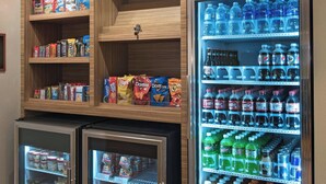 Un espace de vente proposant des collations et des boissons, notamment une section réfrigérée pour les boissons et un congélateur pour les produits emballés.