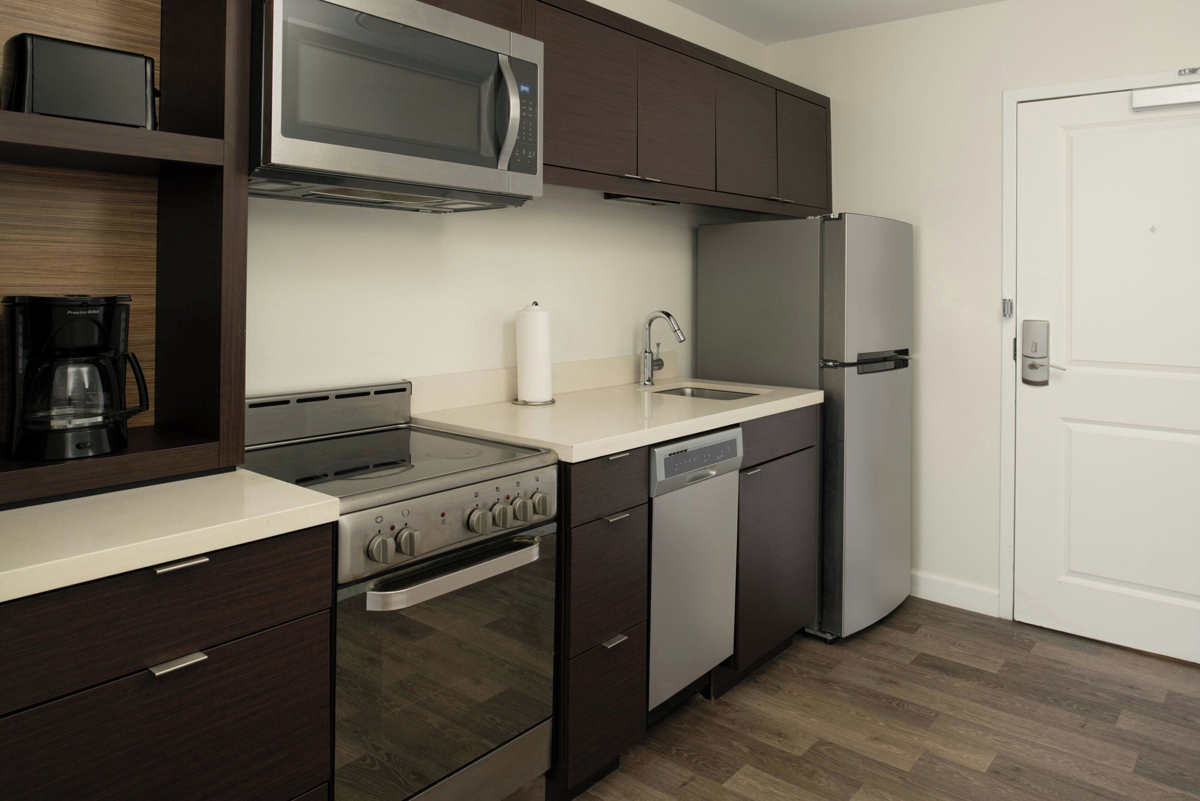 A modern kitchen with a built-in oven, microwave, and dishwasher.