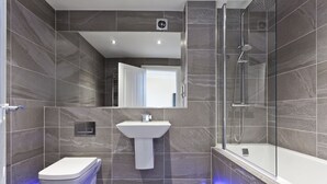 Ein modernes Badezimmer mit Toilette, Waschbecken und Dusche.
