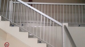 Een trap met witte leuningen en een balustrade, die naar een verdieping leidt.