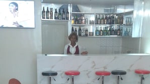 Een bar met zitplaatsen en een barman.