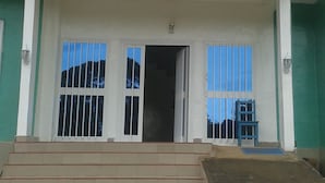 Een gebouw met verschillende vlaggen, een trap die naar de ingang leidt, en een blauwe lucht zichtbaar door de ramen.