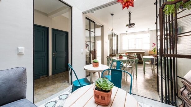 A dining area with a round table, chairs, and potted plants. - La Palomilla (Mexico City)