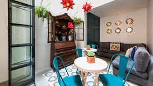 A cozy living room with a wooden cabinet, teal chairs, a round table, and a sofa. - La Palomilla (Mexico City)