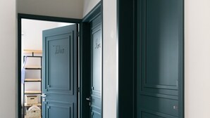 A hallway with dark wooden doors, a wooden floor, and a yellow line marking. - La Palomilla (Mexico City)