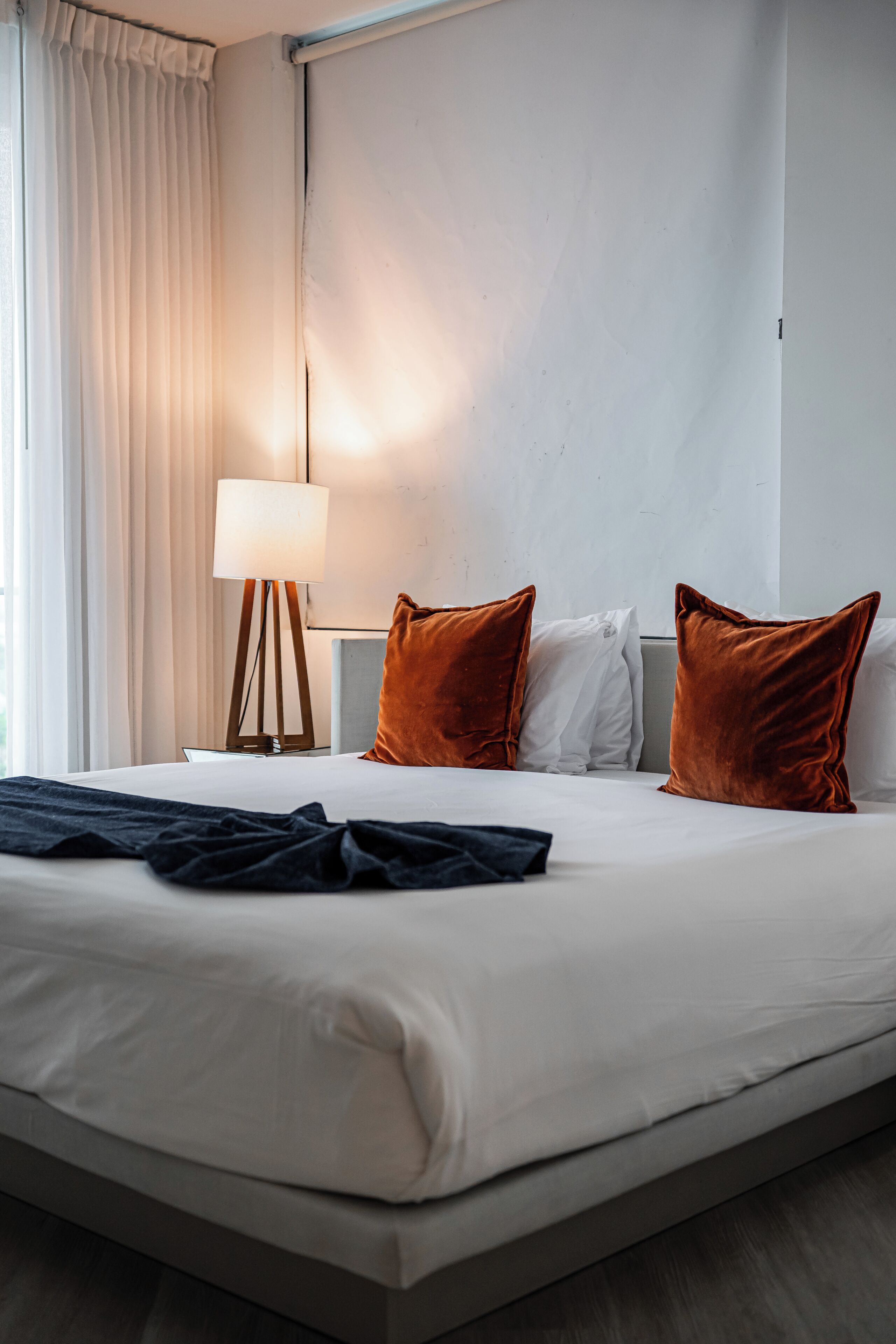 Ein Hotelzimmer mit einem großen Bett, einer Nachttischlampe und zwei Kissen.