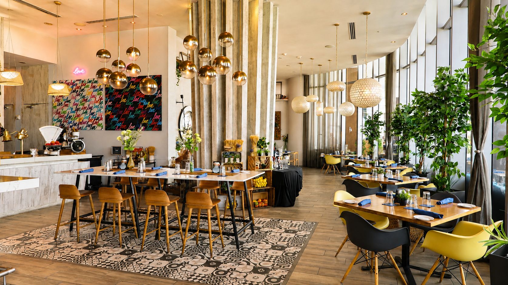 A spacious dining area with multiple tables and chairs, a patterned rug, and hanging spherical light fixtures.