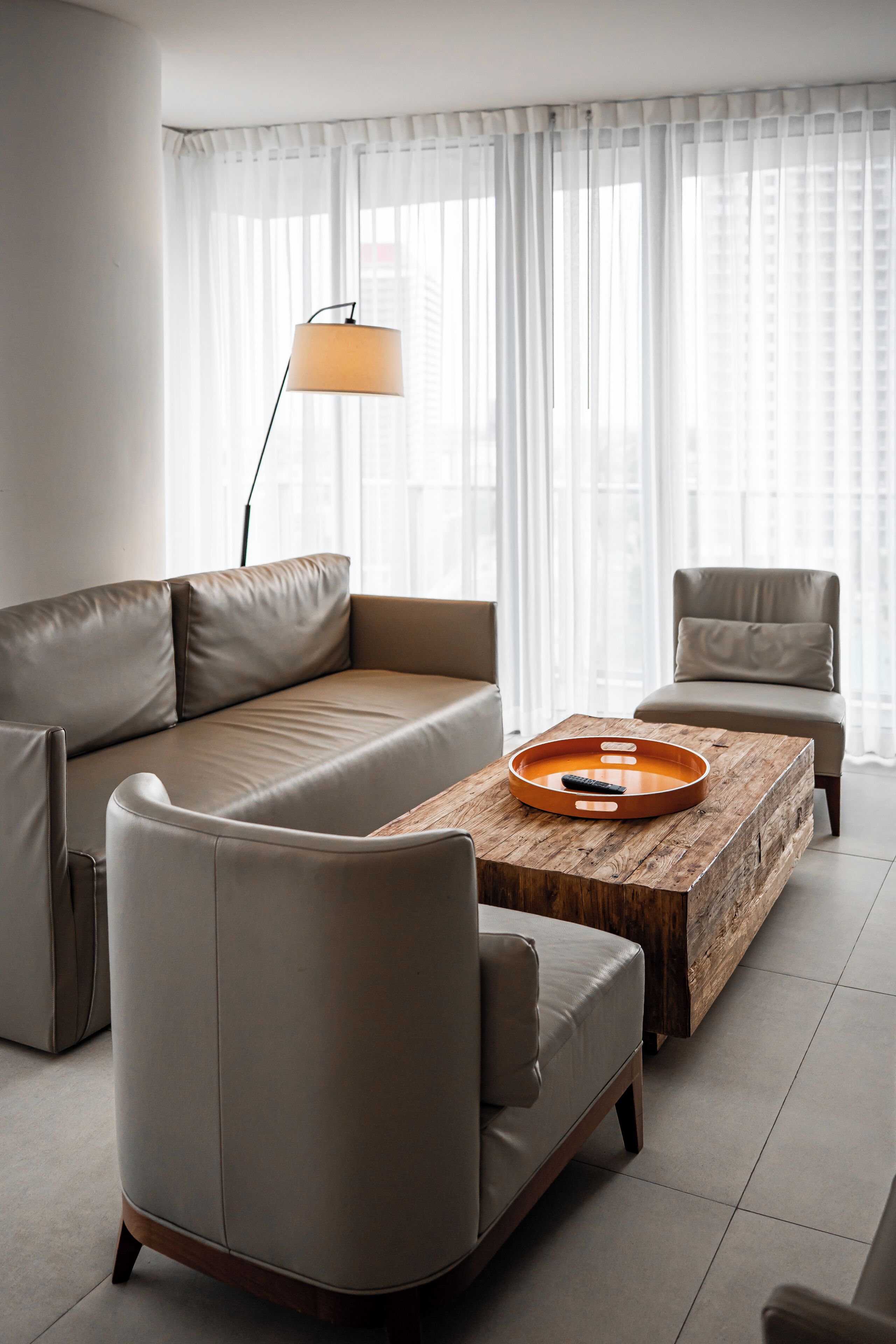 En moderne stue med sofa, lænestol og sofabord med bakke.