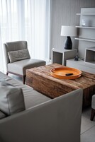 Uma sala de estar moderna com um sofá, uma mesa de centro e uma luminária.