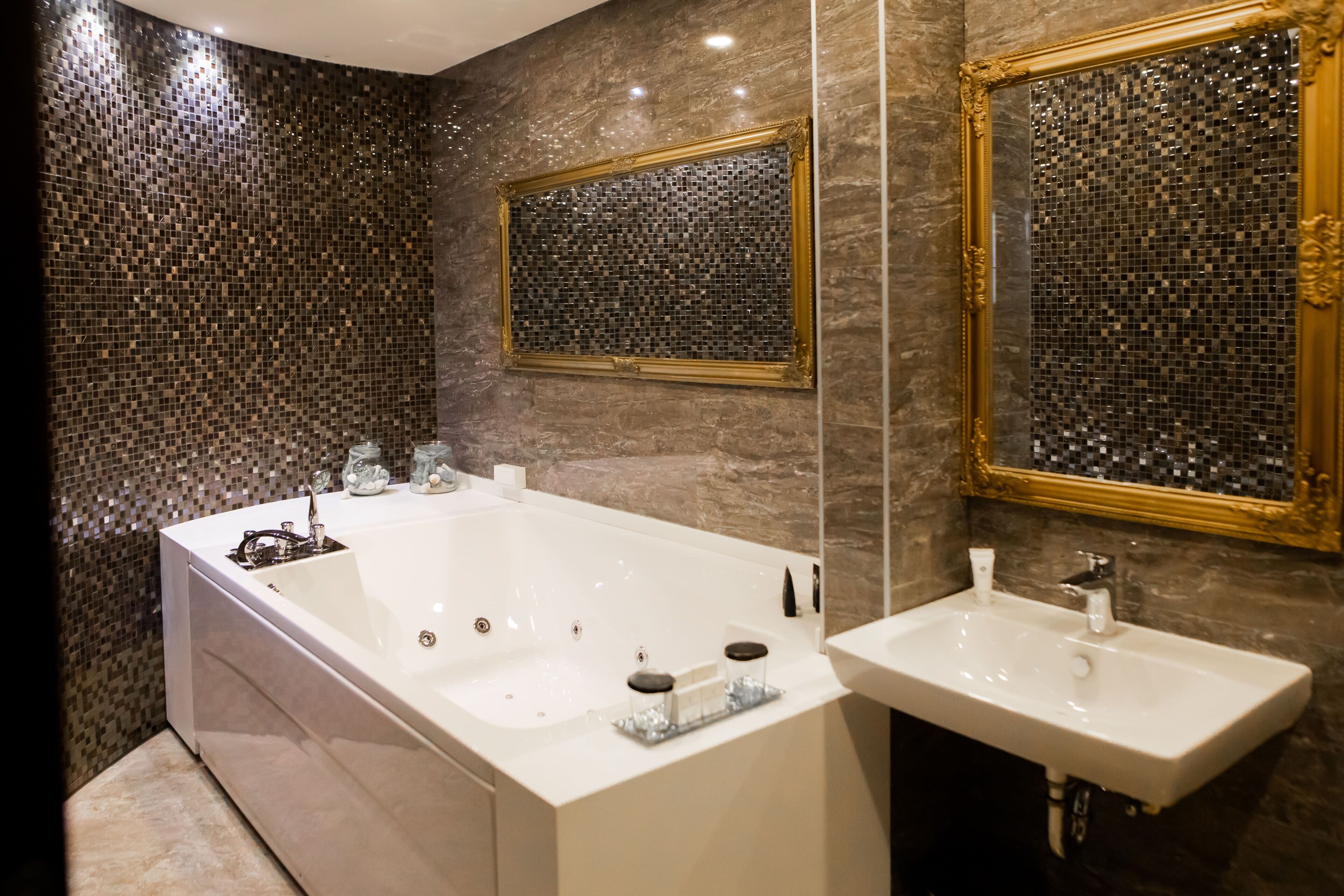 A modern bathroom with a large bathtub, a sink, and two mirrors.