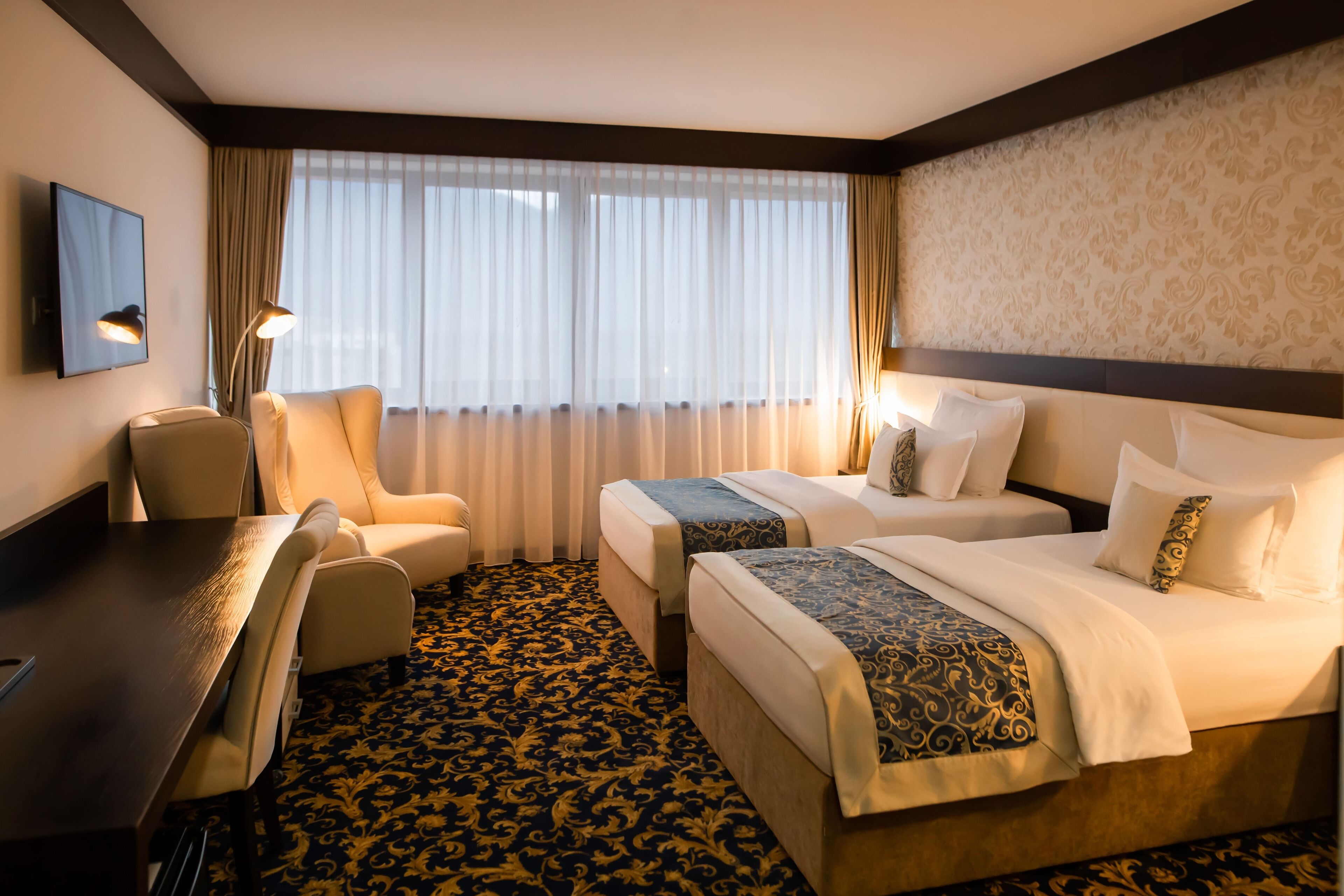 Una habitación de hotel con dos camas, un escritorio y una silla.