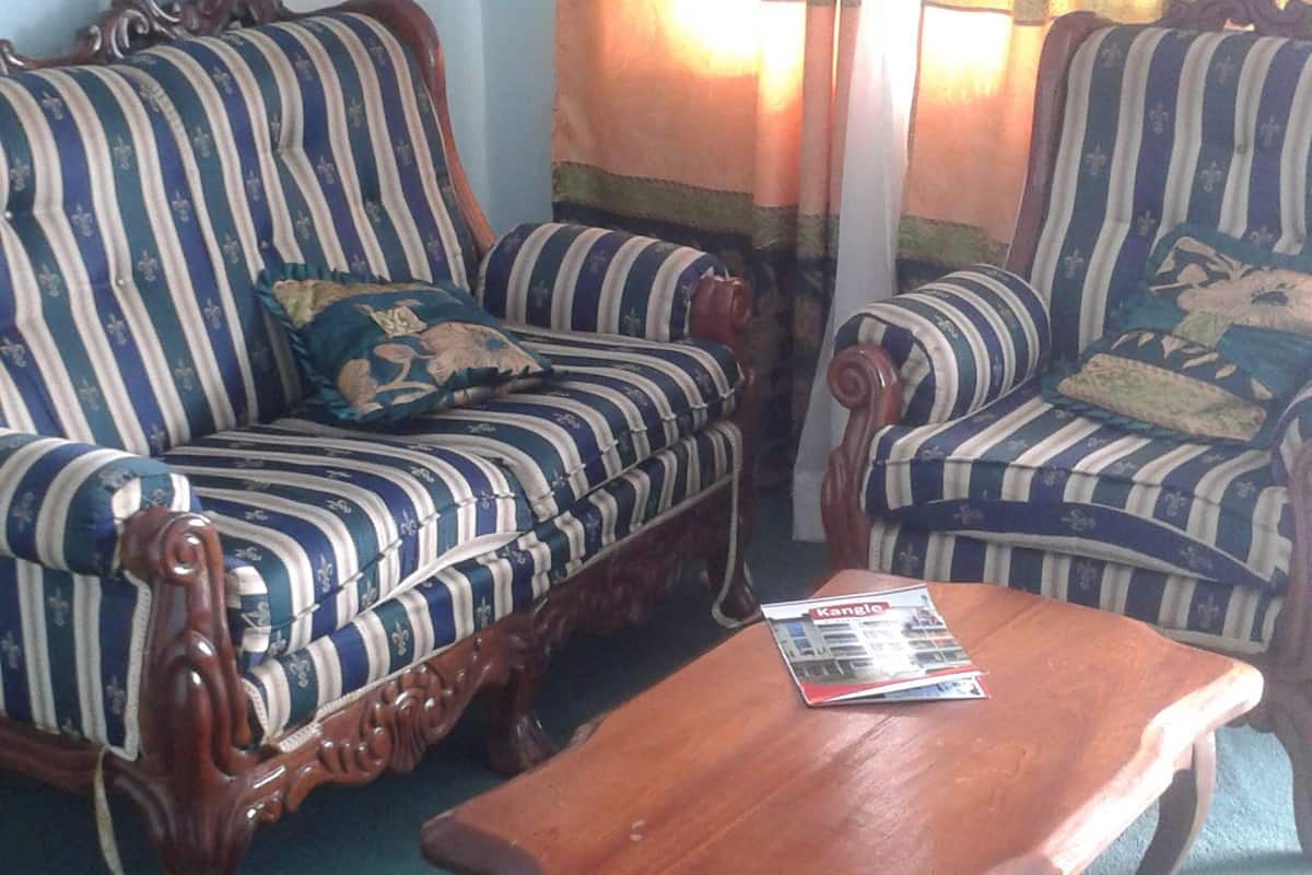 A living room with two striped sofas, a wooden coffee table, and a floral curtain.