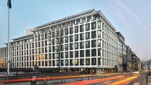 Un edificio moderno con fachada de entramado, ventanas amplias y techo plano.