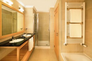 Bathroom features a bathtub, sink, and shower area with a vanity and towel rack.