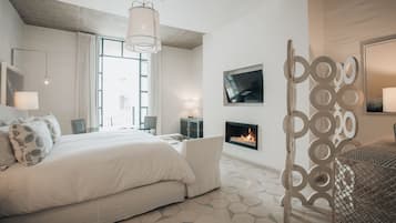 Un dormitorio moderno con una cama grande, una chimenea y un panel decorativo de metal.