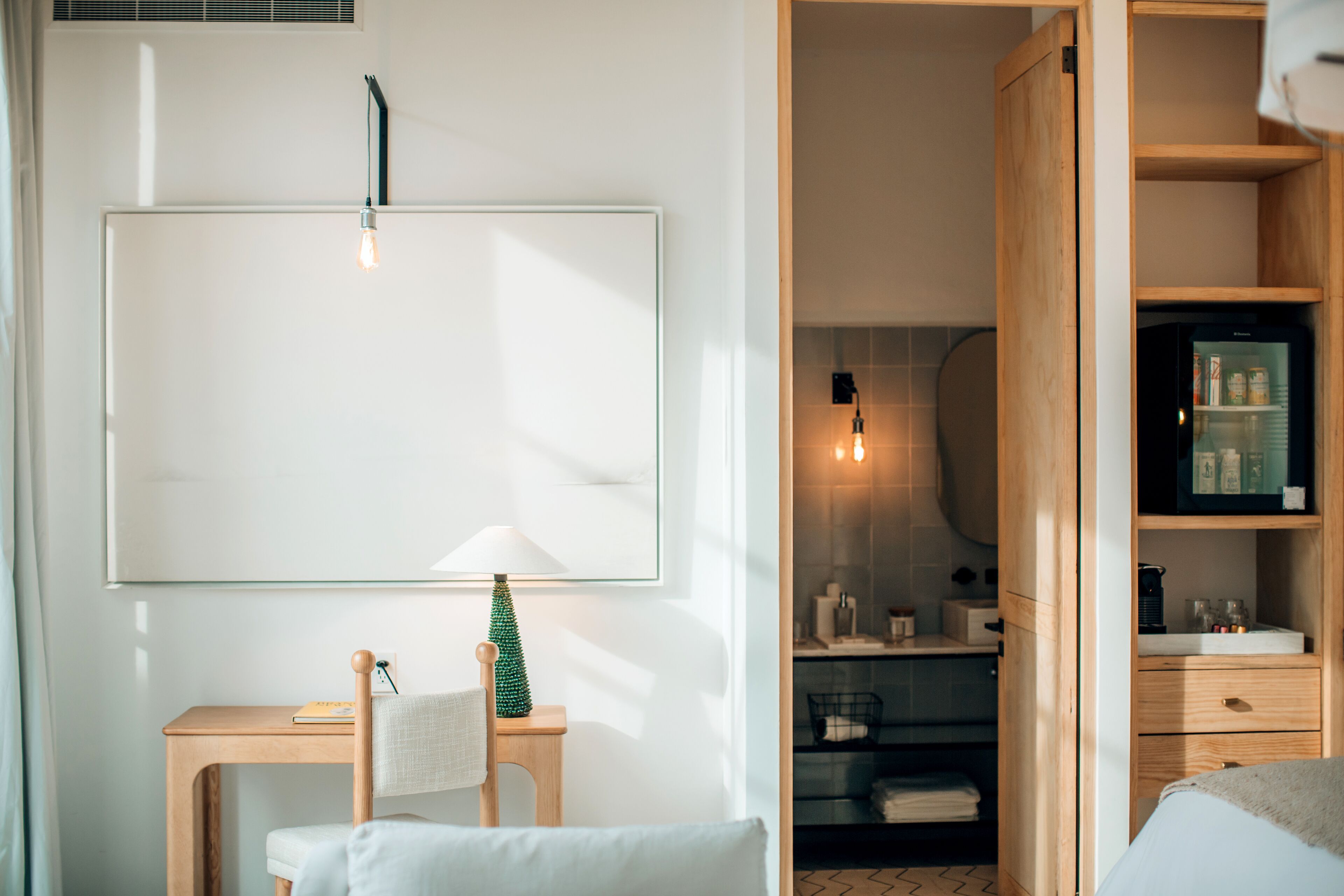 A modern bathroom with a wooden vanity, a towel rack, and a mirror.
